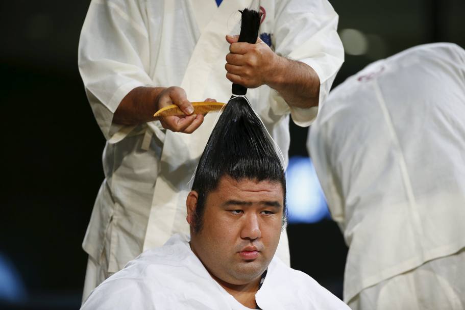 La preparazione della speciale capigliatura di un lottatore di sumo prima della gara (Reuters)